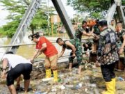 Pemkot Bontang Tinjau Lokasi Banjir, Dialog dengan Warga dan Sampaikan Kendala Teknis Wawali Bontang, Agus Haris membantu warga membersihkan sampah saat banjir di area Bontang Utara (foto: prokompim)