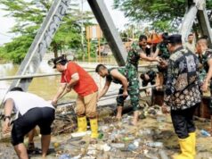 Pemkot Bontang Tinjau Lokasi Banjir, Dialog dengan Warga dan Sampaikan Kendala Teknis Wawali Bontang, Agus Haris membantu warga membersihkan sampah saat banjir di area Bontang Utara (foto: prokompim)