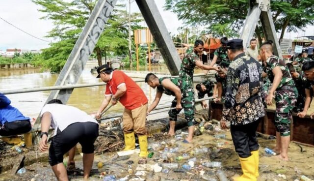 Wawali Bontang, Agus Haris membantu warga membersihkan sampah saat banjir di area Bontang Utara (foto: prokompim)